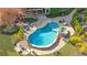 Aerial view of a backyard oasis with a beautiful in-ground pool, spa, patio, and lush landscaping at 2260 Wood Falls Dr, Cumming, GA 30041