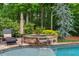 Backyard spa with stone surround, adjacent to the pool area with mature landscaping at 2260 Wood Falls Dr, Cumming, GA 30041