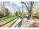 Landscaped backyard with a stone patio, fire pit, and outdoor seating area surrounded by mature trees at 3605 Wood Valley Ne Ct, Brookhaven, GA 30319