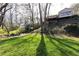 Grassy backyard with an outdoor seating area nestled amongst mature trees at 3605 Wood Valley Ne Ct, Brookhaven, GA 30319