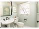 Powder room featuring pedestal sink, toilet and a framed mirror at 3605 Wood Valley Ne Ct, Brookhaven, GA 30319