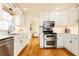 Well-lit kitchen with stainless appliances, white cabinets, and hardwood flooring at 3605 Wood Valley Ne Ct, Brookhaven, GA 30319