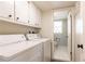 Bright laundry room with modern washer and dryer, with bathroom in adjacent room at 3605 Wood Valley Ne Ct, Brookhaven, GA 30319