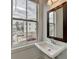 Modern powder room with pedestal sink and a large window overlooking the neighborhood at 1273 Harvest Park Ln, Suwanee, GA 30024