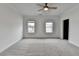 Spacious bedroom featuring neutral carpeting, a ceiling fan, and two windows allowing natural light at 1273 Harvest Park Ln, Suwanee, GA 30024