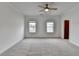 An airy bedroom features neutral carpet, paint and two windows that let in natural light at 1273 Harvest Park Ln, Suwanee, GA 30024