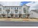 Stylish townhouse row showcases a white and brick facade with dark accents and well-manicured landscaping at 1273 Harvest Park Ln, Suwanee, GA 30024