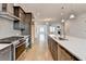 A kitchen features stainless steel appliances, a tiled backsplash, and an island with quartz countertops at 1273 Harvest Park Ln, Suwanee, GA 30024