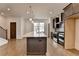 A kitchen features an island with quartz countertops, stainless steel appliances, and wood flooring at 1273 Harvest Park Ln, Suwanee, GA 30024