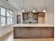 Modern kitchen featuring a large island with quartz countertops and designer pendant lighting at 1273 Harvest Park Ln, Suwanee, GA 30024
