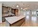 Open concept kitchen features stainless appliances, island with seating, and hardwood floors at 1273 Harvest Park Ln, Suwanee, GA 30024