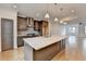 Open concept kitchen features stainless appliances, island with seating, and hardwood floors at 1273 Harvest Park Ln, Suwanee, GA 30024