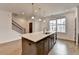 A kitchen island with quartz countertops faces a staircase, wood flooring, and recessed lighting at 1273 Harvest Park Ln, Suwanee, GA 30024