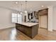 Modern kitchen featuring a large island with quartz countertops and designer pendant lighting at 1273 Harvest Park Ln, Suwanee, GA 30024