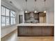 Kitchen island with stainless steel appliances, quartz countertops, pendant lighting, and wood flooring at 1273 Harvest Park Ln, Suwanee, GA 30024