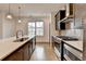 A kitchen features an island with quartz countertops, stainless steel appliances, and wood flooring at 1273 Harvest Park Ln, Suwanee, GA 30024