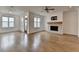Bright living room features hardwood floors, a ceiling fan, and a stone fireplace at 1273 Harvest Park Ln, Suwanee, GA 30024