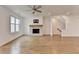 Cozy living area with a stone fireplace, ceiling fan, and large windows for natural light at 1273 Harvest Park Ln, Suwanee, GA 30024