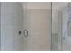 Contemporary shower with marble-look tiling, frameless glass door, and built-in bench at 1273 Harvest Park Ln, Suwanee, GA 30024