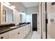 Bright bathroom with dual sinks, granite counters, white cabinets, and a large glass-enclosed shower at 1583 Elixir Sw Ave, Atlanta, GA 30314