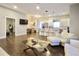 Open-concept living area with hardwood floors flowing into a modern kitchen with stainless steel appliances and island seating at 1583 Elixir Sw Ave, Atlanta, GA 30314