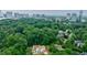 Aerial view of home showing roof, surrounding trees, and city skyline in the background at 2983 Habersham Nw Ct, Atlanta, GA 30305