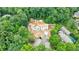 Aerial view of white brick home in wooded area showing roof design and landscaping at 2983 Habersham Nw Ct, Atlanta, GA 30305