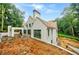 White brick home with modern design, wood shingle roof, and pool under construction in wooded lot at 2983 Habersham Nw Ct, Atlanta, GA 30305