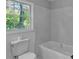 Bright bathroom featuring modern tiling and a soaking tub with a view of the outdoors at 4373 Sun Valley Blvd, Atlanta, GA 30344
