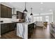 Modern kitchen with stainless steel appliances, dark cabinets, marble countertops and an island with bar seating at 1181 Rambler Cross, Atlanta, GA 30312