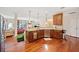 Open kitchen with stainless steel appliances, wood cabinets, hardwood floors, and granite countertops at 153 Newcastle Walk, Woodstock, GA 30188