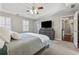 This main bedroom features tray ceilings, a ceiling fan and a gray dresser with mounted television at 1609 Twin Courts Sw Ln, Marietta, GA 30008