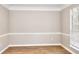 A bright living room with wood flooring, neutral walls, and large window views at 4751 Lorient Ct, Snellville, GA 30039
