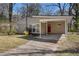 Charming single-story home with a quaint carport and a red front door, set amidst lush greenery at 2254 Whites Mill Rd, Decatur, GA 30032