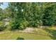 Large backyard featuring a well-kept lawn and a black chain link fence separating the yard from the dense surrounding trees at 4408 Meadowwood Dr, Loganville, GA 30052
