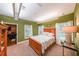 Bedroom with light-green walls, wood floors, and a bed between two windows with white curtains at 4408 Meadowwood Dr, Loganville, GA 30052
