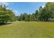 Expansive green front lawn with mature trees providing privacy and curb appeal at 4408 Meadowwood Dr, Loganville, GA 30052