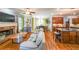 Open-concept living room featuring a stone fireplace, hardwood floors, and seamless flow to kitchen at 4408 Meadowwood Dr, Loganville, GA 30052