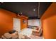 Home theater with projector screen, recliner seating, and orange walls with a black ceiling at 4408 Meadowwood Dr, Loganville, GA 30052