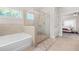 Relaxing bathroom with soaking tub, glass shower, and neutral tile, steps from the main bedroom at 4826 Ralin Ct, Atlanta, GA 30331