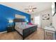 Bedroom featuring a queen bed with a colorful comforter, ceiling fan, and a blue accent wall at 4826 Ralin Ct, Atlanta, GA 30331