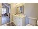 Neutral bathroom with white vanity, decorative mirror, and view to bedroom at 1620 Rising Mist Ln, Cumming, GA 30041