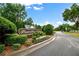 Street view featuring community signage surrounded by lush landscaping, enhancing curb appeal at 1620 Rising Mist Ln, Cumming, GA 30041