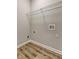 Neutral laundry room with wood look flooring and wire shelving at 1620 Rising Mist Ln, Cumming, GA 30041