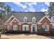 Beautiful two-story brick home featuring dormer windows and manicured landscaping at 2758 Chieftain Run, Duluth, GA 30097