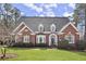 Charming brick home with a manicured front lawn, arched entryway, and symmetrical design at 2758 Chieftain Run, Duluth, GA 30097