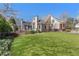 Backyard featuring a lush lawn, mature trees, and home exterior views, including a screened-in porch at 700 Clubside Dr, Roswell, GA 30076