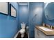 Well-lit half-bathroom with blue walls, modern fixtures, and dark hardwood floors at 700 Clubside Dr, Roswell, GA 30076