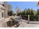 Outdoor deck area with dining table, chairs, and a bench overlooking a serene, wooded backyard at 700 Clubside Dr, Roswell, GA 30076