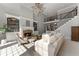 Bright living room features a stone fireplace, built-in shelving, and a graceful staircase at 700 Clubside Dr, Roswell, GA 30076